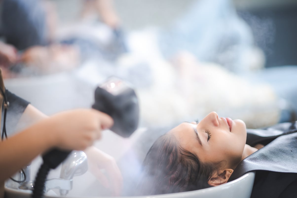 Young woman pampering herself at salon with hair spa, hair c