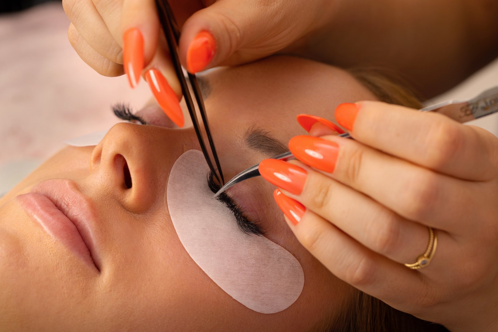 Hands Of Beautician Using Tweezers For Applying False Eyelashes